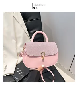 Detail of pink leather handbag featuring a crystal-embellished flap and golden swivel lock