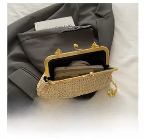 Détail de l'intérieur spacieux du sac en paille beige avec fermoir à boule dorée élégant
