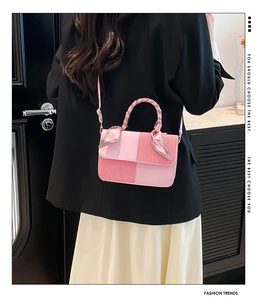 Detail of pink patchwork crossbody bag with scarf-wrapped handle on female model