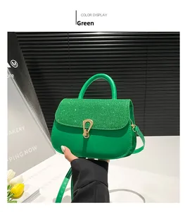 Detail view of green handbag featuring glittery lid and gold hardware clasp