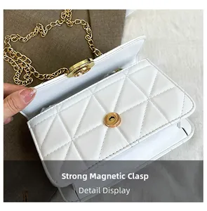 Detail view of the white quilted crossbody bag showing the strong magnetic closure buckle