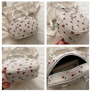 Detail view of the cherry print handbag showing the interior capacity and side construction