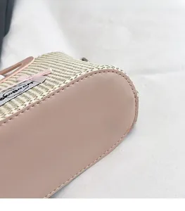 Close-up of woven texture with pink leather stitching and decorative ribbon bow