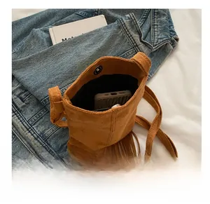 Detail of brown suede fringe crossbody bag interior showing smartphone storage capacity