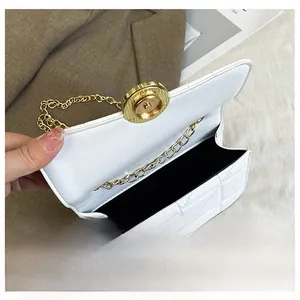 Detail view of white quilted square bag showing interior capacity and golden turn-lock