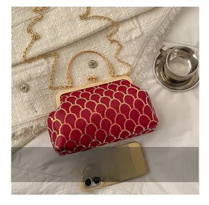Détail du sac pochette à paillettes rouges avec motif écailles et fermoir métallique