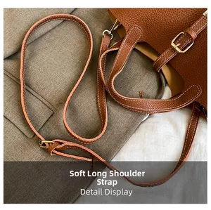 Detail of adjustable caramel brown lychee leather shoulder strap with golden buckle