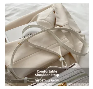 Detail of adjustable strap with gold buckles on a beige woven texture crossbody bag
