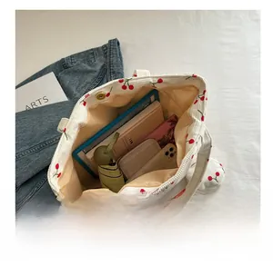 Detail view of cherry print corduroy tote bag showing large capacity for daily items