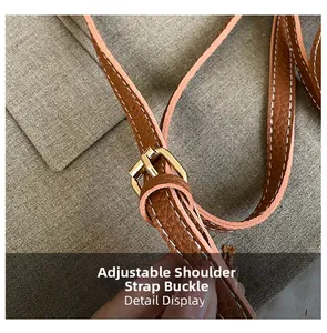 Macro detail of brown lychee leather shoulder strap with gold adjustable metal buckle