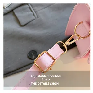 Detail of macaron pink faux leather strap with gold adjustable buckle and metal hook