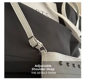 Détail de la bandoulière réglable avec boucle argentée sur un sac en cuir blanc