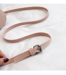 Close-up of pink adjustable leather shoulder strap with silver buckle for straw bucket bag