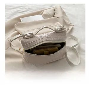 Detail of small box bag showing interior capacity with phone and woven handle