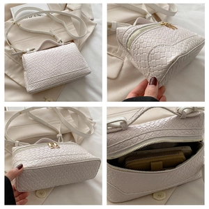 Detail showing hand-woven texture, dual zippers and interior capacity of the square bag
