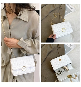 Detail view of quilted white crossbody bag showing chain strap and interior storage capacity