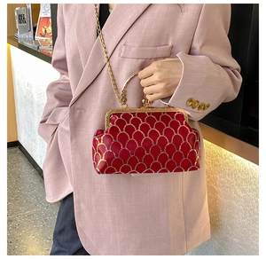 Chic red velvet handbag with gold scale embroidery and metal chain handle on model
