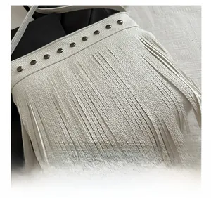 Gros plan sur cuir blanc texturé avec rivets métalliques et longues franges
