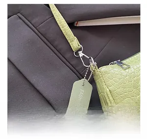 Detail of light green crocodile embossed bag with silver hardware and fashion tag