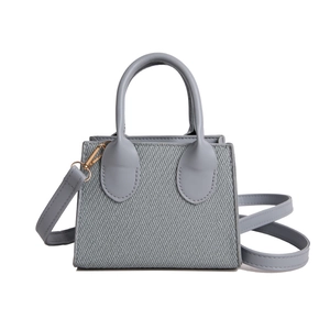 Light blue mini crossbody bag in textured fabric with top handles and gold hardware