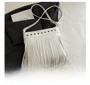 Détail du sac seau blanc avec franges et clous métalliques sur cuir litchi texturé