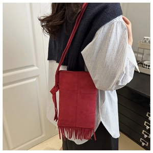 Red suede crossbody bag with bohemian fringes and adjustable knotted shoulder strap