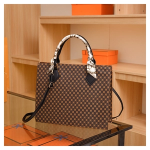 Macro detail of brown leather tote with geometric pattern and decorative silk scarf