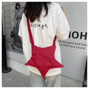 Red star-shaped nylon crossbody bag shown in a casual street style outfit context