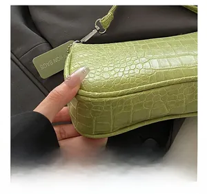 Detail of light green crocodile embossed texture and precision stitching on the handbag