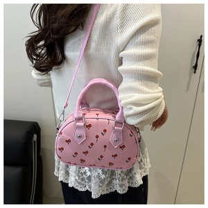Detailed view of pink bowling bag featuring cherry prints and silver-tone hardware