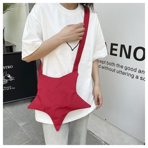 Close-up of a bright red star-shaped crossbody bag with matching nylon shoulder strap