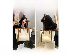 Detailed view of bicolor tote bag showing shoulder and handheld carrying styles