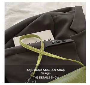 Close-up of the adjustable slim strap and crocodile pattern on this green bag