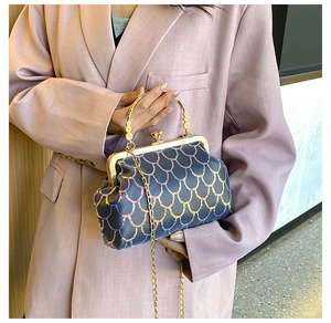 Détail de la broderie écailles de sirène vintage et fermoir doré sur le sac à main