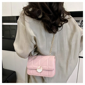 Pink quilted square crossbody bag with gold chain strap shown on a shoulder