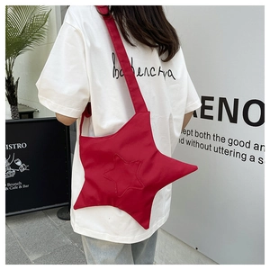 Red star-shaped canvas crossbody bag shown on a model for size and style reference