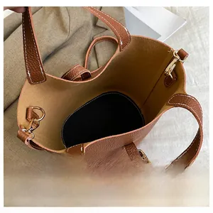 Top view detail of the brown lychee pattern handbag showing spacious interior and golden hardware