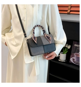 Detail of trendy square bag with printed silk scarf handle and monochrome fabric contrast