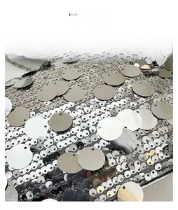 Close-up of silver sequin fabric detailing with layered fish scale metallic reflections