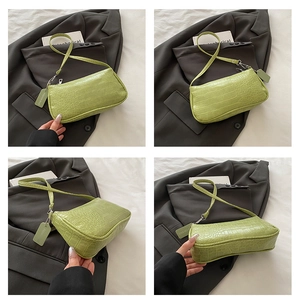 Detail of light green crocodile pattern baguette bag showing fine texture and sleek strap