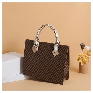 Detail view of small tote bag with brown geometric dots and silk scarf handle decoration