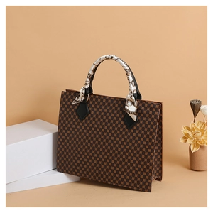 Detailed view of vintage checkered handbag featuring a silk scarf wrapped handle