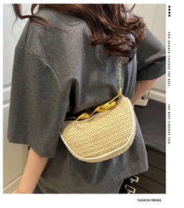 Detail of woven straw crescent bag with unique gold handle and elegant chain strap