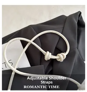Détail d'une bandoulière blanche ajustable à nœud sur une veste de blazer noire