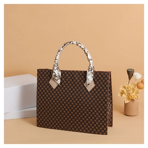 Detail of vintage patterned tote bag featuring a silk scarf wrapped around the top handle