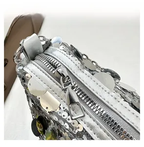 Macro detail of high-quality silver metal zipper and shiny sequins on crescent bag