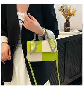 Close-up of green and cream crossbody bag with silk scarf wrapped handle and textured fabric