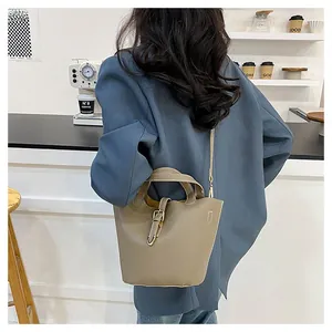 Close-up of elephant grey lychee pattern leather bucket bag with silver buckle in a cafe