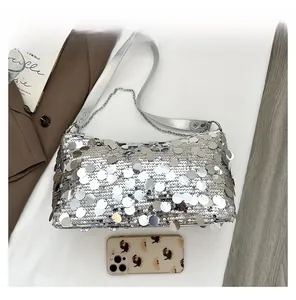 Detail view of silver sequin crescent bag showing interior space next to a smartphone