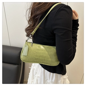 Détail du sac baguette en similicuir embossé crocodile vert clair avec étiquette de mode